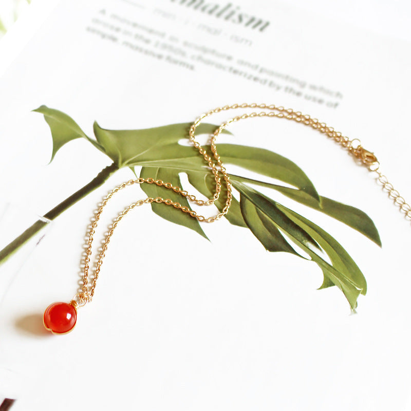 Gold chain necklace featuring a natural crystal pendant women with a vibrant red stone