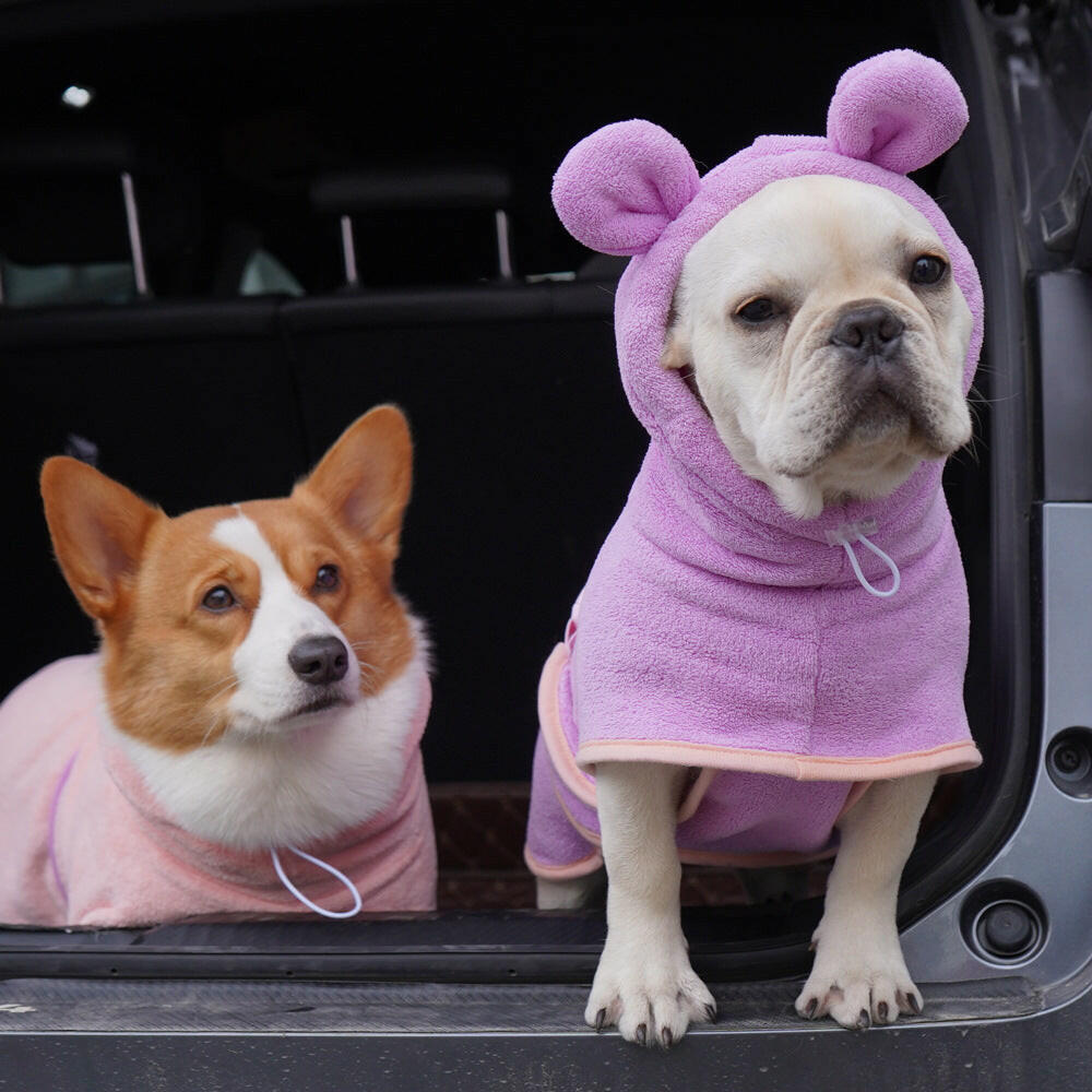 Two dogs in cozy pink bath towels featuring ears, showcasing a super absorbent dog bath towel for quick drying