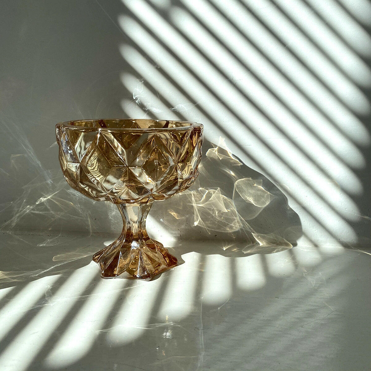 Vintage amber drinking glass with diamond patterns and a decorative base, perfect for elegant table settings