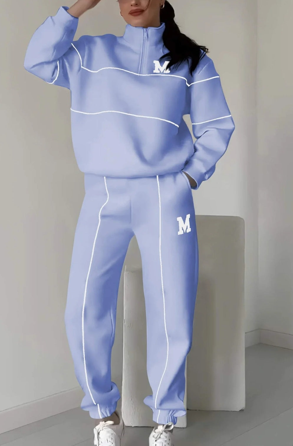 Light blue women's lounge sweatsuit set with white piping and M logo on chest and pants