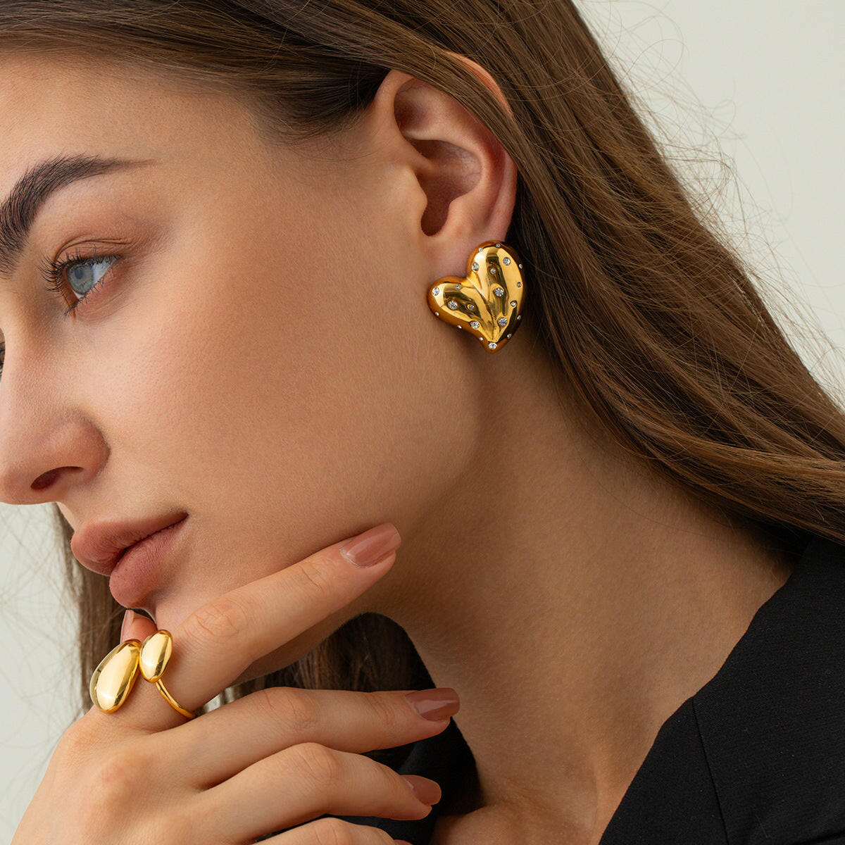 Stylish 18K gold heart earrings on a model showcasing modern elegance and design