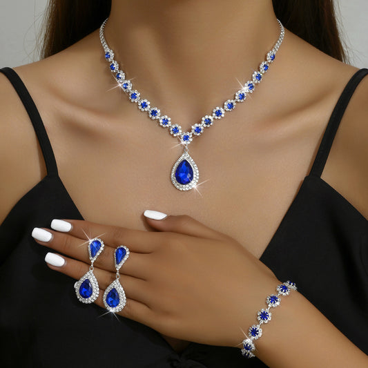 Elegant bridal jewelry set with blue gemstones, featuring necklace, earrings, and bracelet for weddings