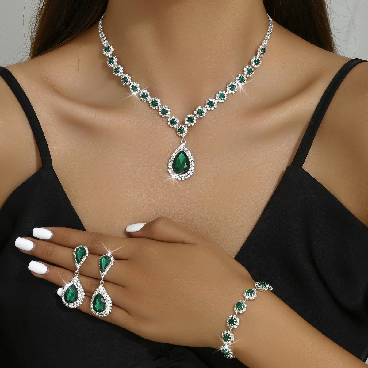 Elegant bridal jewelry set featuring emerald stones with shimmering accents and matching earrings and bracelet